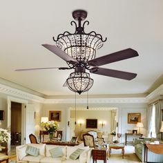 a living room filled with lots of furniture and a chandelier hanging from the ceiling