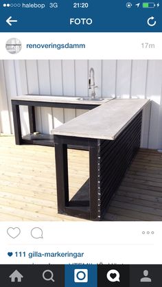 an outdoor sink on top of a wooden floor next to a white wall and window