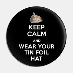 a button with the words, keep calm and wear your tin foil hat on it