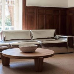 a living room with two couches and a coffee table in front of a window