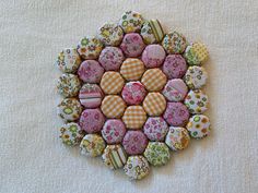 a flower shaped brooch sitting on top of a table