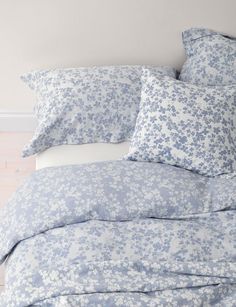 a bed with blue and white flowers on it