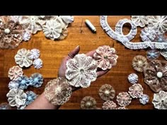 a person is working on some lace flowers