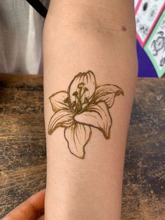 a woman's arm with a tattoo on it that has a flower drawn on it