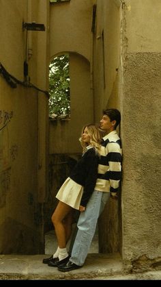 a man and woman standing in an alleyway