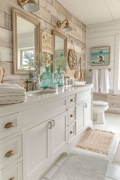 a bathroom with two sinks, mirrors and towels hanging on the wall next to each other