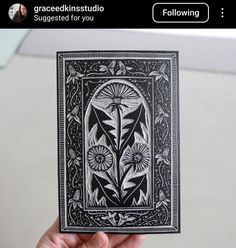 a hand holding up a card with an image of flowers on it