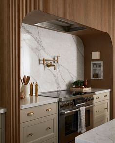 a kitchen with marble counter tops and gold accents on the cabinets, along with an oven