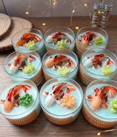 there are many small bowls with fish in them