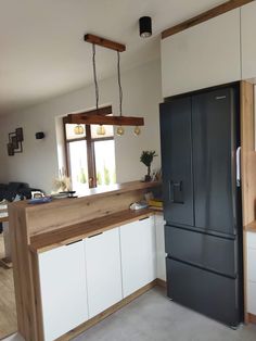 a kitchen with a black refrigerator freezer next to a window