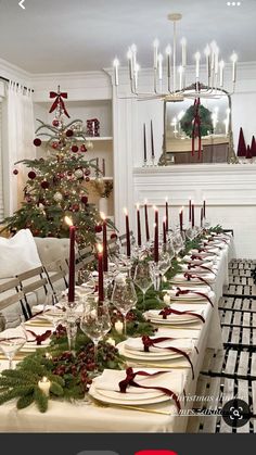 a dining room table set for christmas dinner with candles and decorations on the long table