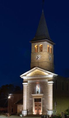 a church with a clock tower lit up at night