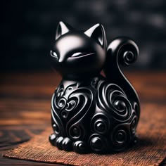 a black cat figurine sitting on top of a wooden table