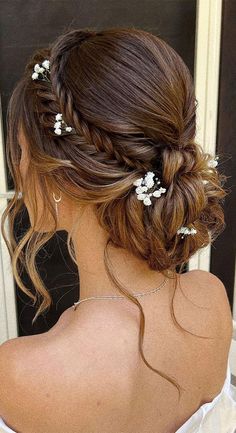 the back of a woman's head with flowers in her hair, wearing a wedding dress