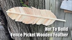 a piece of wood that is attached to a tree with the words hot to build fence picket wooden feather