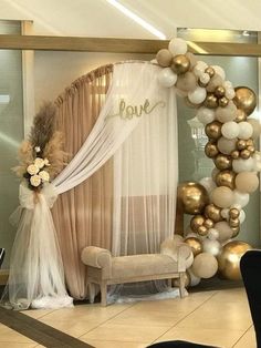 a balloon arch is decorated with gold and white balloons