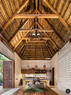 a large wooden table in the middle of a room with a ceiling made of wood