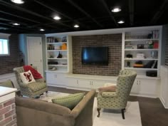 a living room filled with furniture and a flat screen tv mounted on a wall above it