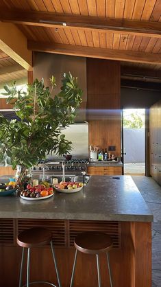 a large kitchen with an island and two bar stools next to the counter top