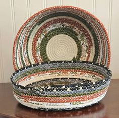 two baskets sitting on top of a wooden table next to a white and brown wall