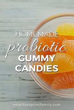 a glass bowl filled with gummy candies on top of a white wooden table