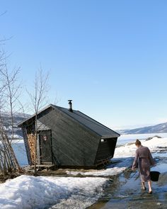 a person walking in the water near a shack