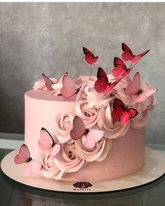 there is a pink cake with butterflies on it