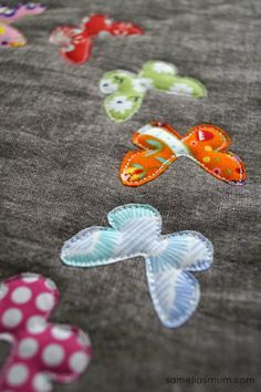 the fabric has been stitched together with different colors and designs on it, including butterflies