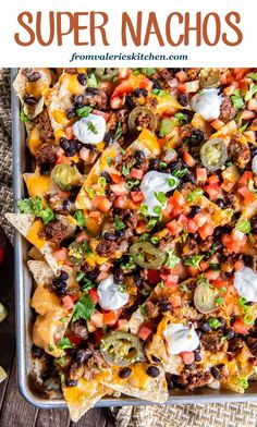 an overhead view of nachos in a baking dish with sour cream on top