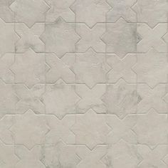 a white tile wall with an interesting pattern