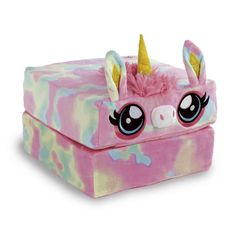 a pink and blue box with a stuffed unicorn on it's face, sitting in front of a white background