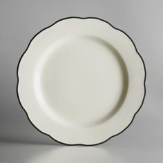 an empty white plate with black trim on it