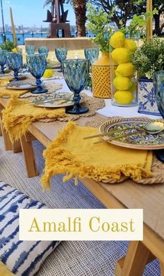 the table is set with blue and yellow dishes, lemons, and other decorative items