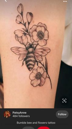 a bee and flowers tattoo on the thigh