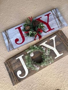 two wooden signs sitting on top of a floor next to each other with christmas decorations