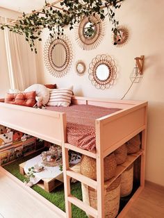 a bed with lots of pillows on top of it next to a shelf filled with baskets