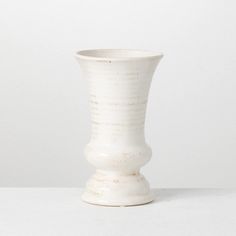 a white vase sitting on top of a table