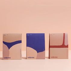 three boxes with different designs on them sitting next to each other in front of a pink wall