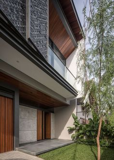 an exterior view of a modern house with wooden doors and grass in the foreground