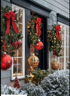 christmas decorations hanging from the side of a building in front of a window with red and gold baubons