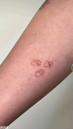 a person with a small tattoo on their arm that has two cats and a dog