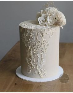 a close up of a cake on a table with white frosting and flower decorations