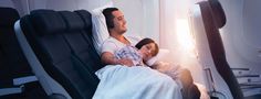 a man and woman laying in an airplane bed