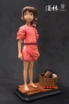 a statue of a girl standing on top of a wooden table next to a basket