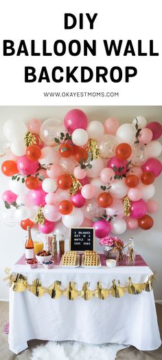 balloon wall backdrop with pink, red and white balloons hanging from it's ceiling