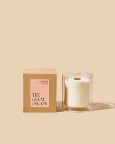 the great escape candle in front of a box on a beige background with a shadow