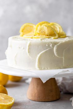 a white cake topped with lemons on top of a table