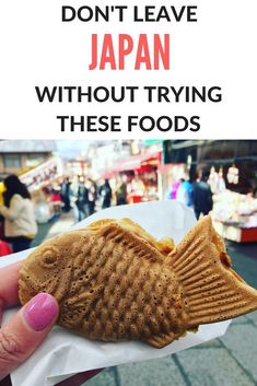 a person holding up a piece of food with words above it that says don't leave japan without trying these foods