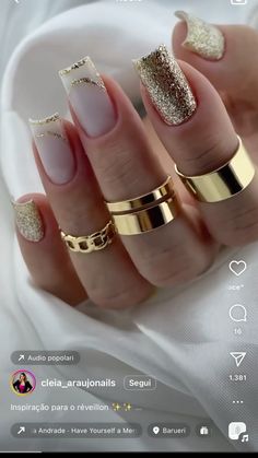 a woman's hand with gold and white manicures on it, including two rings