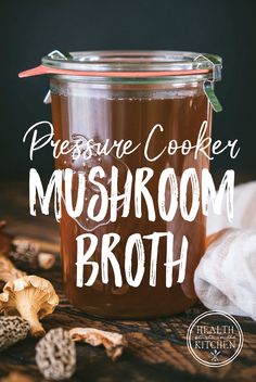 pressure cooker mushroom broth in a glass jar with mushrooms around it and the words pressure cooker mushroom broth